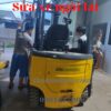 Hai nhân viên lắp đặt hệ thống bóng đèn xe nâng điện ngồi lái
